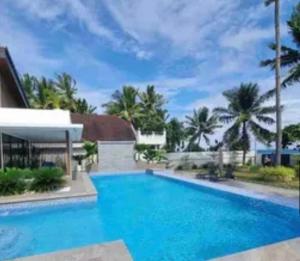 a large swimming pool with blue water in front of a house at Cebu beachfront house  +15 photos