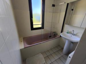 a bathroom with a sink and a tub and a toilet and a window at Grande maison avec jardin in Liffol-le-Grand