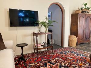 a living room with a couch and a tv on a wall at Casa Miramare - Marina Beach in Southbroom +9 photos