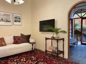 a living room with a couch and a tv at Casa Miramare - Marina Beach in Southbroom