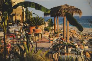 a beach with tables and chairs and the ocean at Apartment Sandri in Gjilek