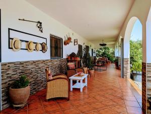 a lobby with chairs and a brick wall at Casa Rural en Ohanes, 1 dormitorio - El Cortijo Escondido, La Rosa in Ohanes