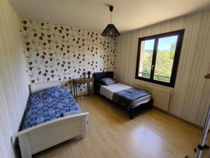 a bedroom with two beds and a window at Grande maison avec jardin in Liffol-le-Grand