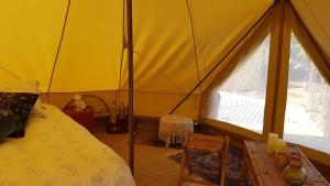 a bedroom with a tent with a bed and a window at Bohème glamping expérience in Berson