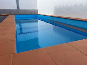 a swimming pool with blue water in a building at Casa Joy in La Oliva