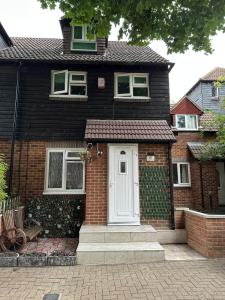 a black house with a white door and a brick at SONG House in London