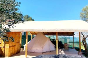 a white tent under a pavilion in a yard at Glamping Kulmi in Shkodër +23 photos