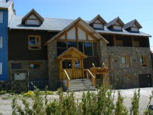 een groot huis met een houten deur ervoor bij Ruca Pehuen Eco-Lodge De Montaña in Caviahue