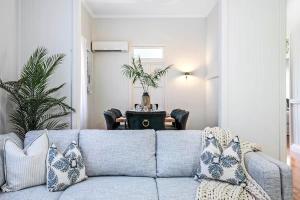 a living room with a blue couch and a table at Central Haven Milton 4BR Sleeps 10 in Brisbane +19 photos
