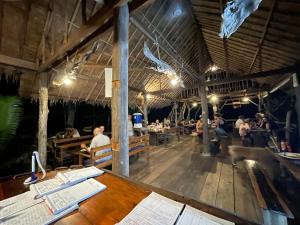 a restaurant with a table with books on it at Lily's Riverhouse in Koh Rong Island