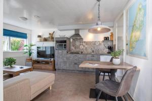 a kitchen and living room with a table and a couch at Aangenaam Texel Duo Bungalow in De Koog
