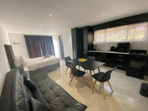 eine Küche und ein Wohnzimmer mit Tisch und Stühlen in der Unterkunft FlowithLin Guesthouse in Durban