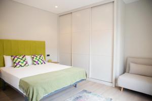 a bedroom with a bed and a chair at Zabella Ossau - Nuevo ático a estrenar en el tubo in Zaragoza