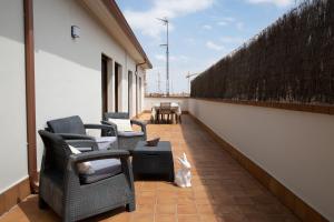 a balcony with chairs and a cat sitting on it at Zabella Ossau - Nuevo ático a estrenar en el tubo in Zaragoza
