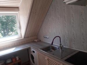 a small kitchen with a sink and a window at Apartment Nautilus in Jūrmala