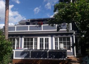 a white house with a porch and a balcony at Apartment Nautilus in Jūrmala