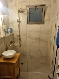 a bathroom with a shower with a sink and a mirror at חלום מול נוף הכנרת in Tiberias +12 photos