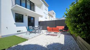 a patio with chairs and a table in front of a house at 3star 1950s house, 3 bedrooms, 6 people, walk to beach center in Royan