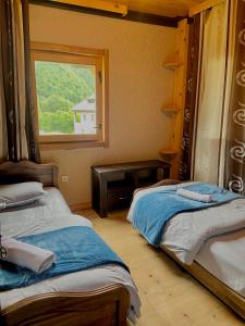 due letti in una stanza con finestra di Guest House Shuan a Chokhuldi