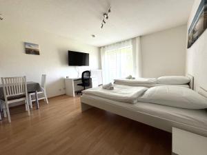 a bedroom with two beds and a table and a window at WuP Living Apartment am Stadtwald TG Parkplatz in Augsburg
