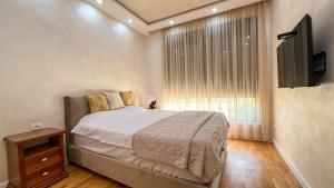 a bedroom with a bed and a tv and a window at Harmony Apartment 2 in Bar