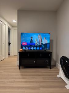 a flat screen tv sitting on a stand in a living room at Tommy Place in Moncton