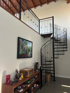 a living room with a spiral staircase and a tv at Casa campo moderna e confortável in Itatiba