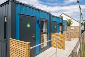 a row of blue shipping container homes at Nodpod Hotel in Bristol