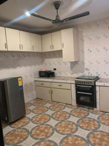 a kitchen with a stove and a floor with pizzas at StayComidad in Dawhwenya