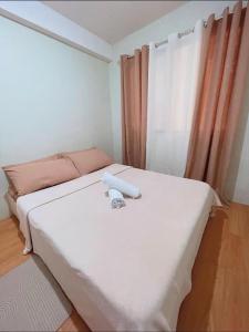 a small room with a bed and a window at 2 Bedroom Condo Davao - Nest and Nook in Davao City