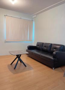 a black leather couch in a living room with a table at 2 Bedroom Condo Davao - Nest and Nook in Davao City