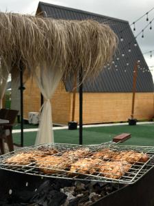 a grill with some food on top of it at Uptown Batumi Yard & Jacuzzi in Batumi