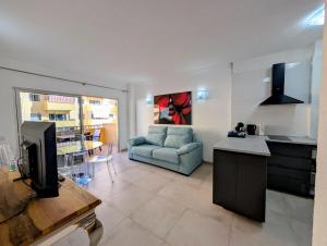 a kitchen and living room with a couch and a table at Los Cristianos Sun and Relax in Tenerife