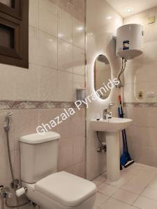 a bathroom with a toilet and a sink and a mirror at Ghazala Pyramids in Cairo