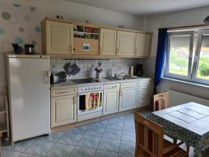 a kitchen with white cabinets and a white refrigerator at Ferienwohnung Beatrice in Zella-Mehlis