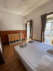 a bedroom with a large white bed and a window at Rota Ria Alojamento Local in Aveiro +59 photos