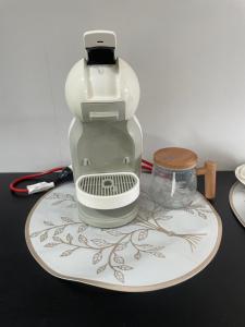 a coffee maker on a plate on a table at Departamento cerca de COP Comité Olímpico PY y Aeropuerto in Luque