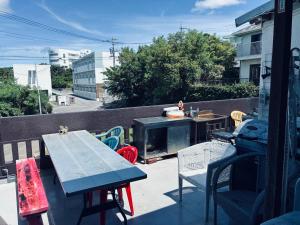 a patio with a table and chairs and a fireplace at Yoko House in Uruma