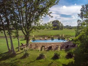 a pool in the middle of a field with trees at HOMOKI LODGE Bed & Beyond Glamping Adult Only in Ruzsa