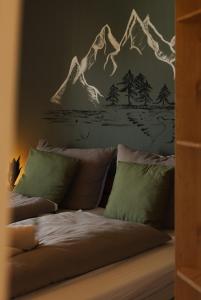 a bedroom with a bed with a mountain mural on the wall at Grünten-Blick Apartment in Sonthofen +20 photos