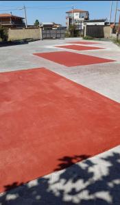 Casa Happy - La mansarda del sorriso con parcheggio privato a Valcorrente في بيلباسو: ملعب كرة سلة أحمر مع ظل على الأرض