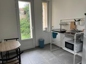 a kitchen with a sink and a table and a window at Studio B1 - Centre-Ville Meaux - Proche Disneyland in Meaux