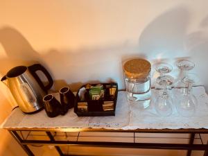a table with wine glasses and a bottle and a jar at Large Room Near City Centre in Belfast +11 photos