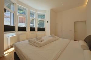 een slaapkamer met een groot wit bed en ramen bij Ausblick apartments in Badenweiler +88 foto's