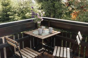 a table with two chairs and a vase of flowers on a balcony at Grünten-Blick Apartment in Sonthofen