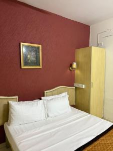 1 cama en un dormitorio con una pared roja en Western e-Inn, en Bangalore