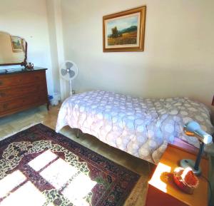 a bedroom with a bed and a dresser and a mirror at i giardini di Ailobran in Narbolia