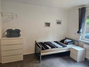 a small bedroom with a bed and a dresser at Ella's Wolke Appartements - EW6 in Zweibrücken