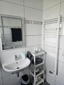 a white bathroom with a sink and a mirror at Ella's Wolke Appartements - EW6 in Zweibrücken