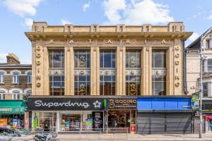 an old building on a street corner with a store at Ensuite Double Godino Hotel by Ilford Station in Ilford